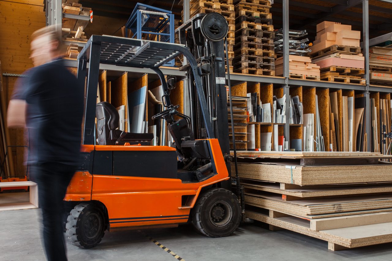 Cariste manoeuvrant un chariot élévateur en entrepôt logistique